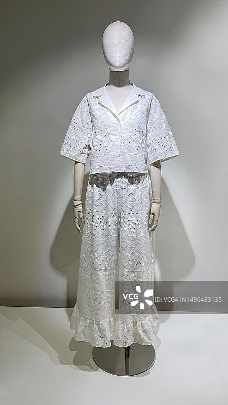 白色休闲服装的变形女性人体模型靠墙站立图片素材