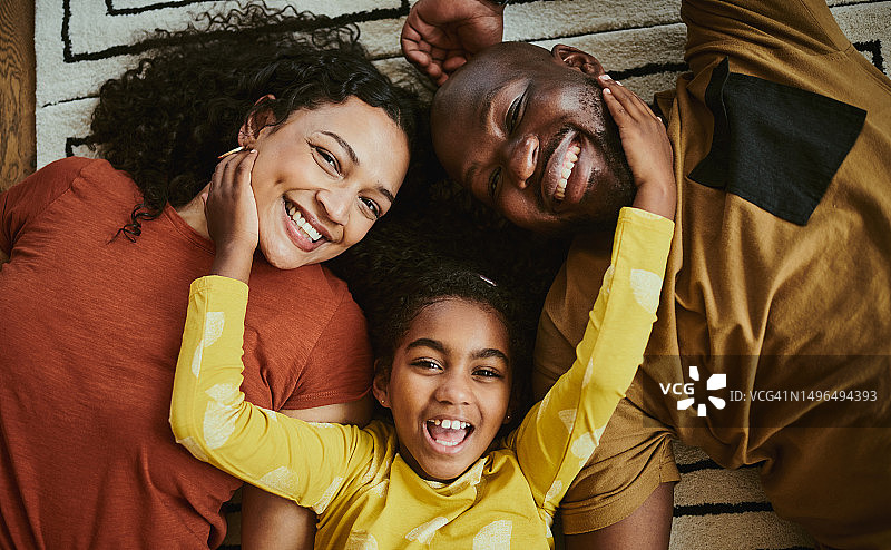年轻的黑人一家三口躺在地上看着镜头图片素材