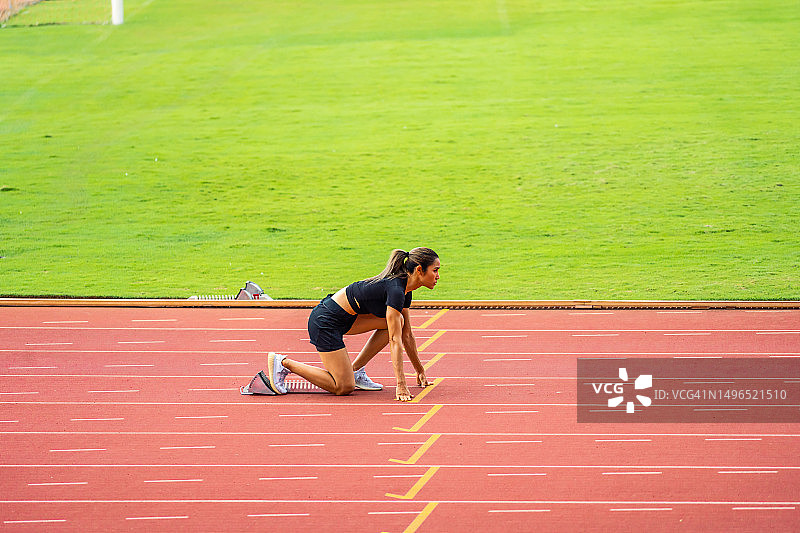 年轻亚洲女运动员在体育场跑道上冲刺，为奥运会马拉松比赛进行训练图片素材