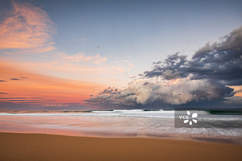 日落照亮海洋上戏剧性风暴的沿海海景图片素材