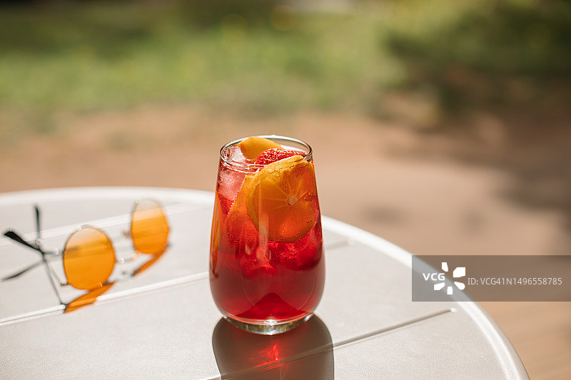特写：夏季鸡尾酒，搭配橙子和草莓片，旁边是一副太阳镜图片素材