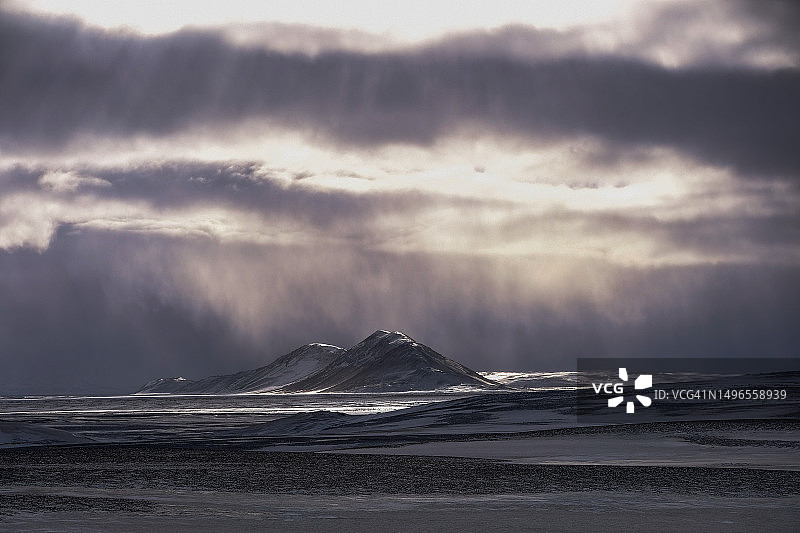 冰岛偏远地区雪暴中阳光穿透云层图片素材