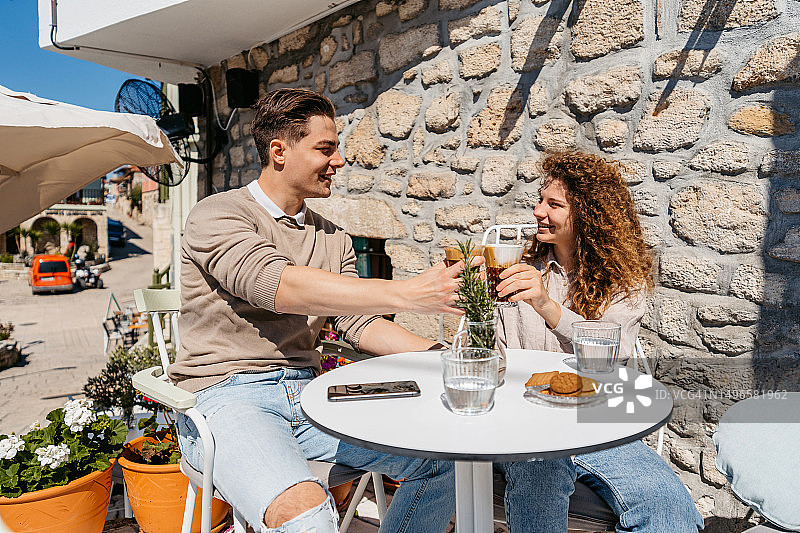 年轻情侣在希腊的街边咖啡馆喝咖啡图片素材