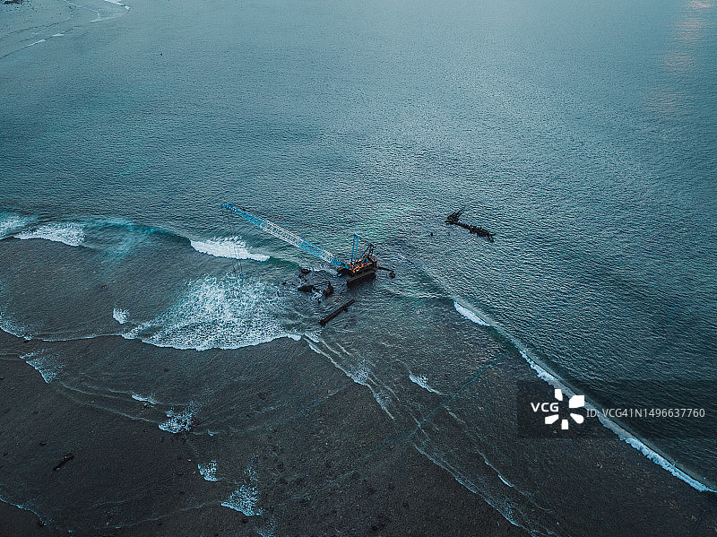 印度尼西亚巴厘岛海边起重机作业的航拍图片素材