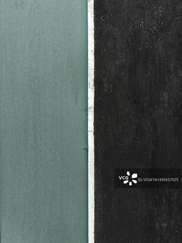 无人机视角：印度尼西亚巴厘岛的黑沙滩和海峡边缘图片素材