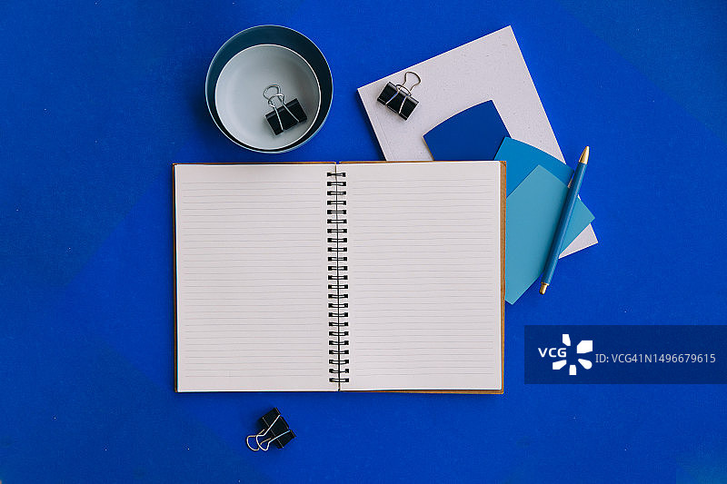 打开的笔记本和办公用品扁平风背景图片素材
