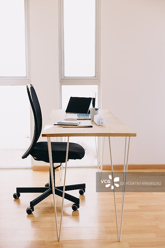 自然光照亮的家庭办公室：木制桌面的办公用品图片素材