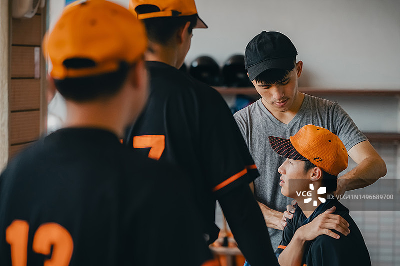 棒球比赛期间，运动教练在休息区按摩手臂，提供运动医疗护理图片素材