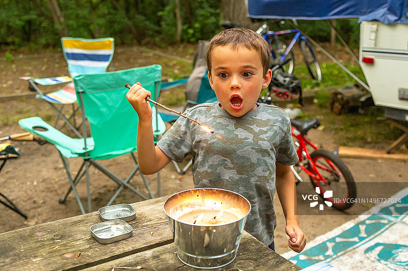 男孩在露营时烧树枝图片素材