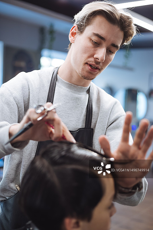 经验丰富的男理发师为青少年理发图片素材