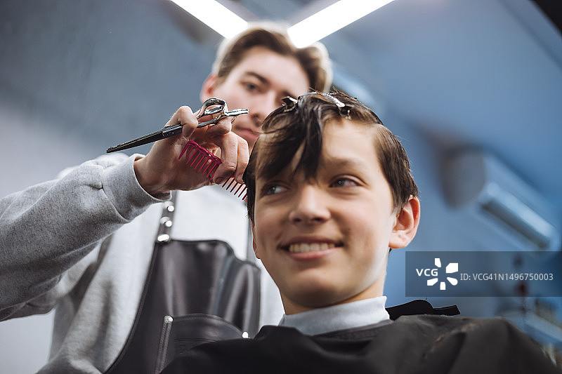 初级造型师为男性青少年理发图片素材