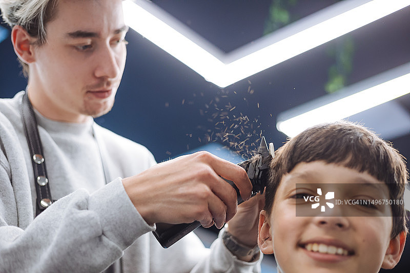 有经验的Gen Z理发师为少年理发图片素材