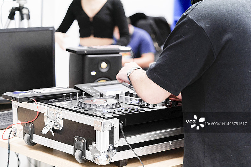 穿着休闲装站在广播电台调音台前的男DJ的背影图片素材