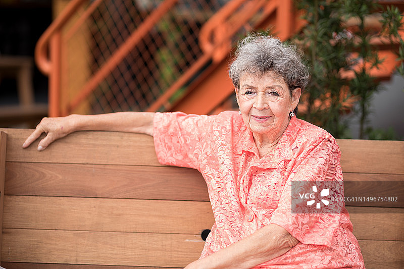 优雅的老年女性坐在木凳上图片素材