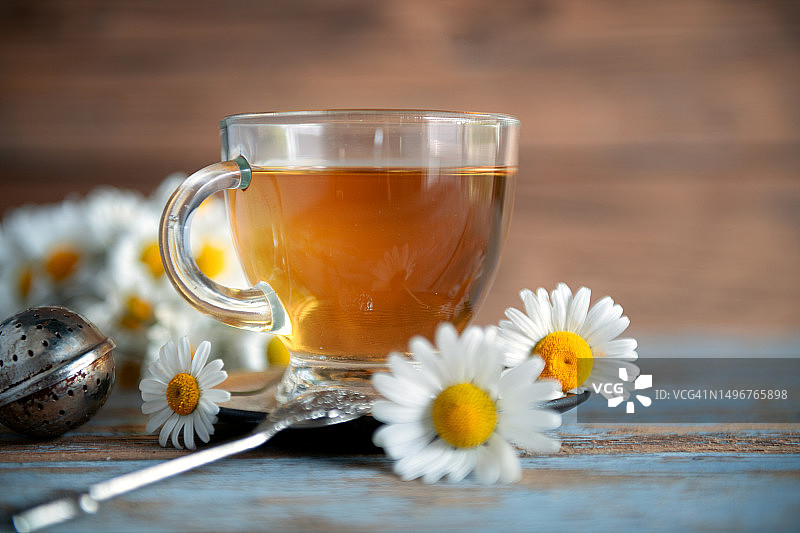 木桌背景上的洋甘菊茶图片素材