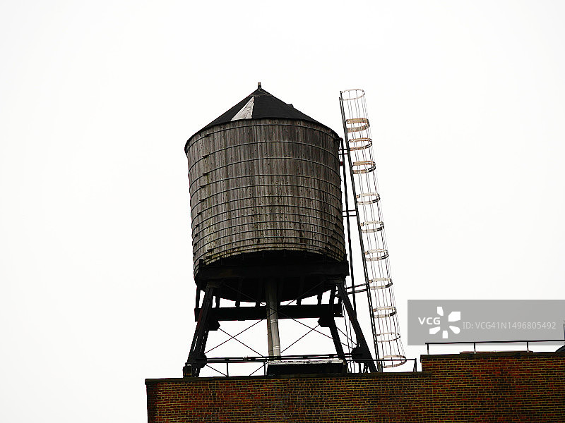 美国纽约曼哈顿一座建筑屋顶上带有金属结构和梯子的木制水箱图片素材