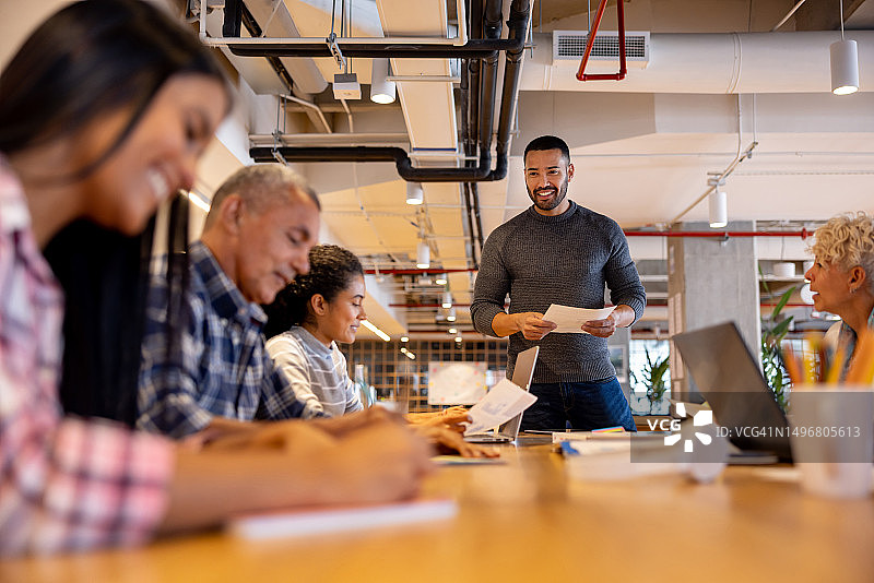 男子在商务会议中向团队做演示图片素材