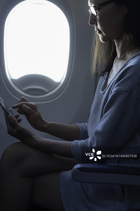 女人在飞机上使用手机图片素材