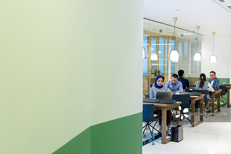 在开放式共享办公室里忙碌的亚裔和多种族白领工人图片素材