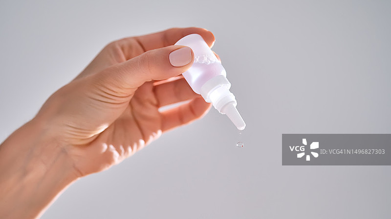 女人拿着一瓶滴鼻液或滴眼液图片素材