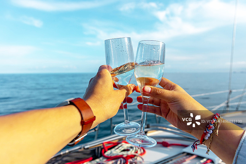 情侣在巴塞罗那海岸的帆船之旅中举杯庆祝图片素材