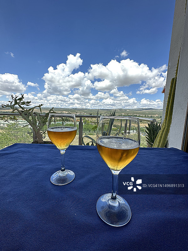 露台上俯瞰广阔橄榄树林的两杯啤酒图片素材