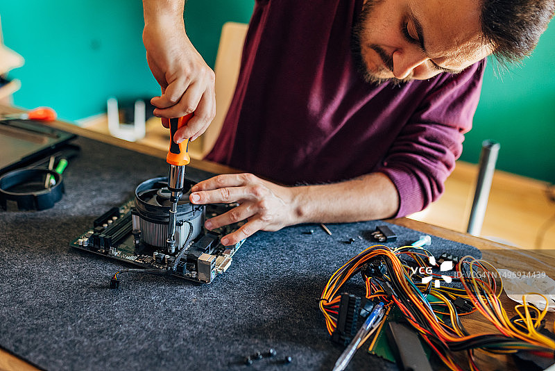 专心将散热器放在电脑处理器上的男人图片素材