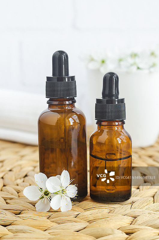 两只装有精油香水、精华液和抗衰老面部精华的小玻璃瓶图片素材