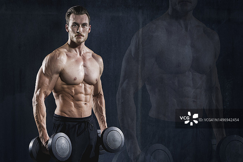 用哑铃做运动的健壮男人图片素材