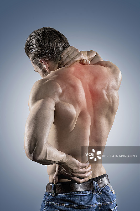 痛苦地扶着脖子和下背部的健壮男人背影图片素材