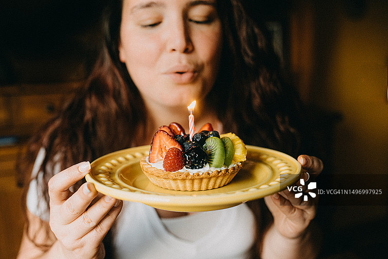 年轻女人手拿水果挞生日蛋糕图片素材