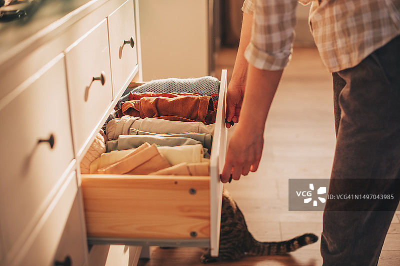 手拿衣物的抽屉柜图片素材
