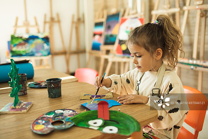 在儿童俱乐部参加绘画活动的可爱的女孩图片素材