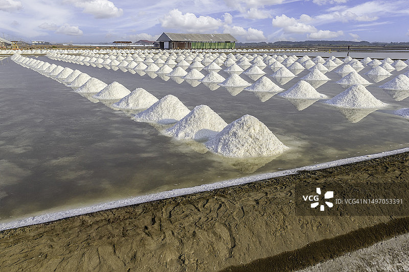 海盐堆在原始盐产品农场用天然海洋盐水制成，准备在发送给工业消费者之前的最后过程。图片素材