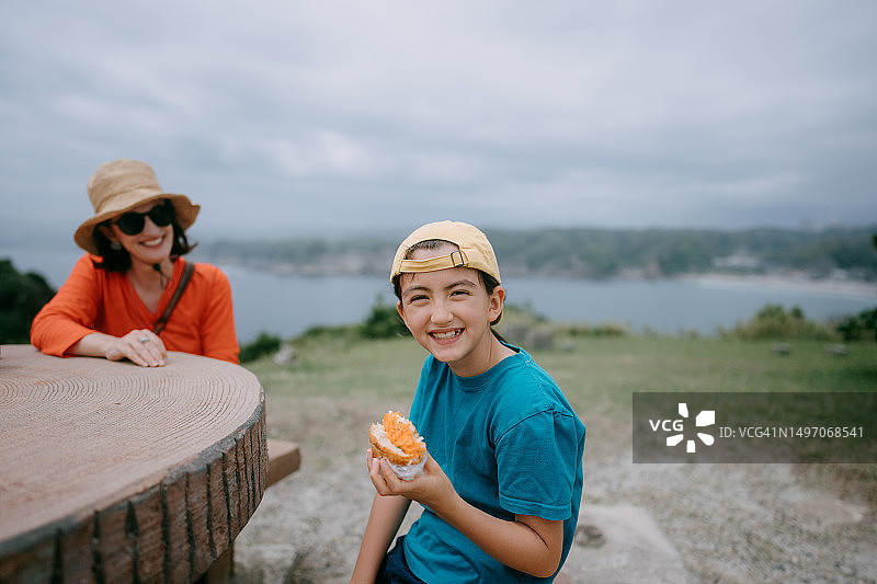 快乐的年轻女孩在沿海徒步旅行时享用午餐图片素材