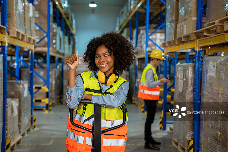 仓库工人拉着托盘车在大型仓库中图片素材