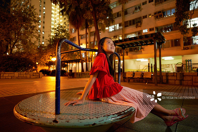 独自坐在游乐场里的亚洲女孩图片素材