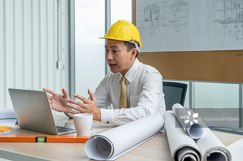 建筑师在施工现场通过笔记本电脑进行视频通话图片素材