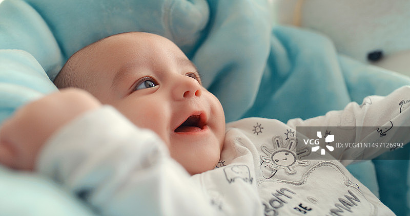婴儿笑声，新生儿早晨在家中床上醒来图片素材