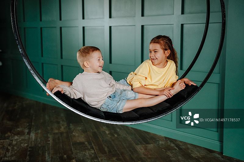 儿童在家坐秋千图片素材