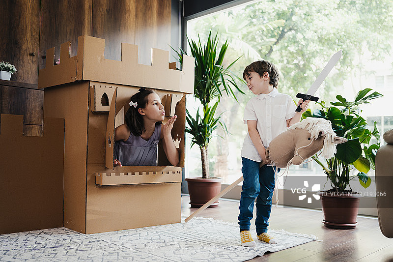公主和王子在家里玩纸板城堡角色扮演游戏图片素材