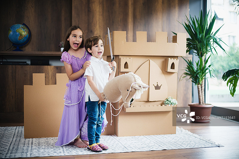 公主和王子在家里玩纸板城堡角色扮演游戏图片素材