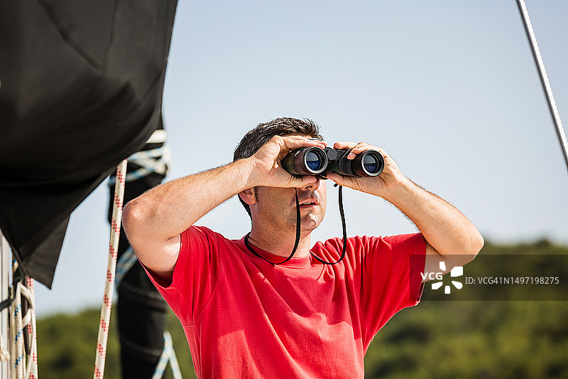 在帆船上拿着望远镜的水手图片素材