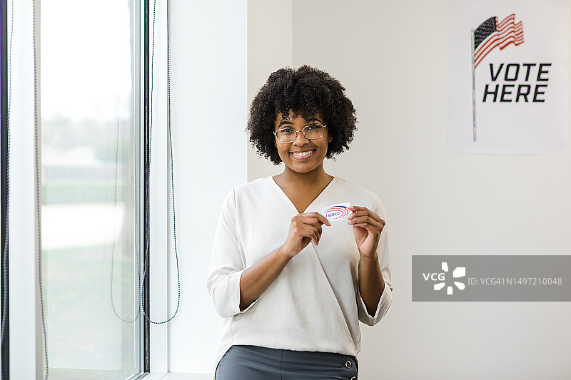 年轻女志愿者在设置投票站前微笑图片素材