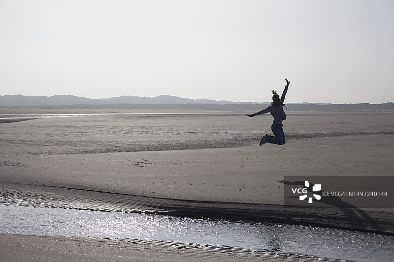 中年妇女在荷兰泽兰省斯豪文-迪沃兰雷内塞海滩上跳跃图片素材