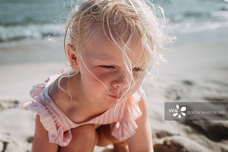 在海滩上玩耍的儿童，头发被风吹起图片素材