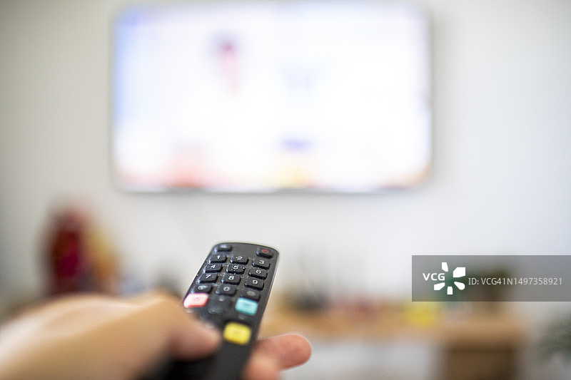 男人手持电视遥控器图片素材