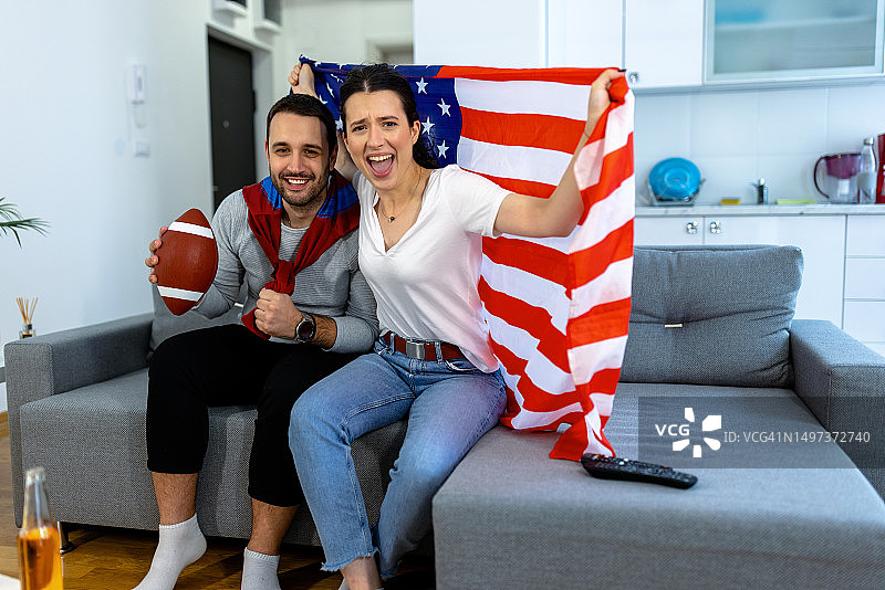 观看橄榄球比赛的快乐情侣支持者图片素材