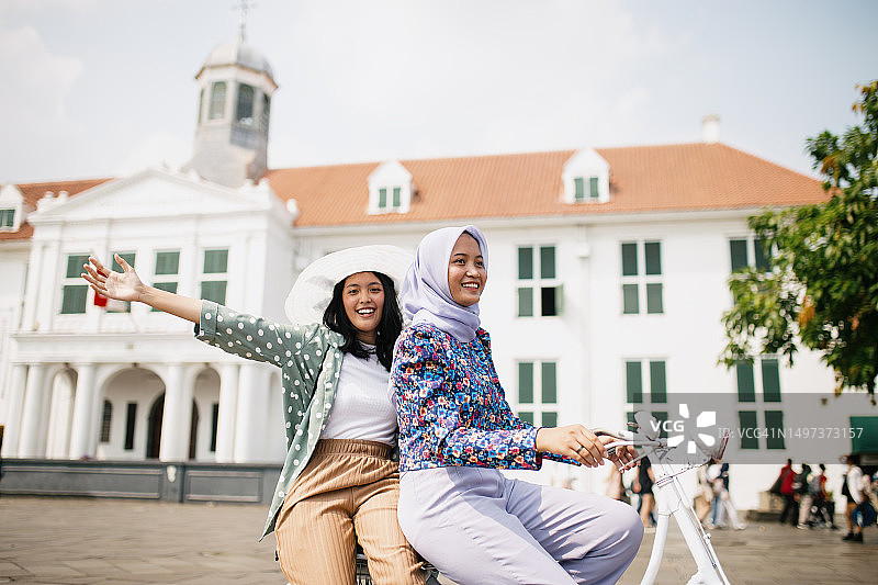 年轻女性好友在旅游景点一起玩耍图片素材
