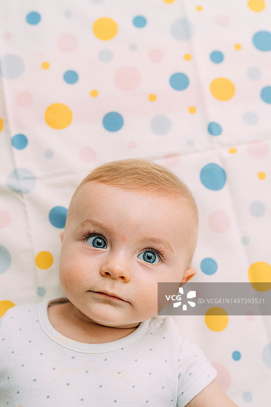 男婴躺在彩色背景布上图片素材